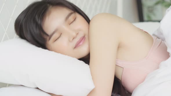 Beautiful asian young woman sleeping lying in bed with head on pillow comfortable and happy.