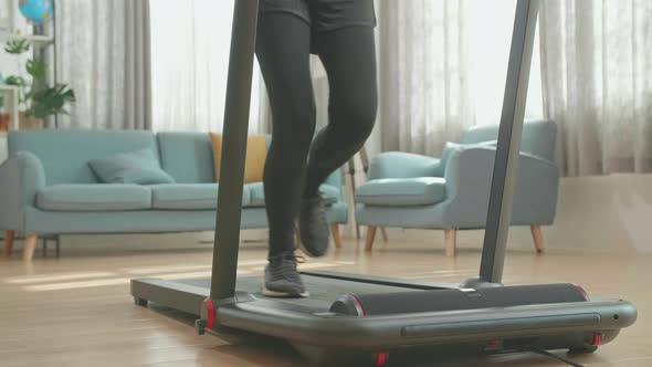 Legs Of Asian Woman Running On A Treadmill At Home