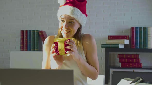 Young Woman in the Office on Christmas Eve in Santa Hat