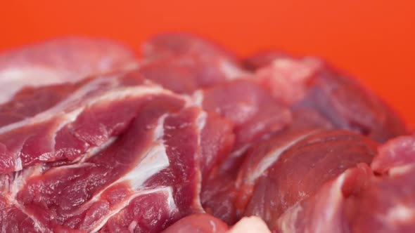 Close-up of raw red fatty meat rotates. Cooking healthy pork meat. Butcher's shop fresh meat.