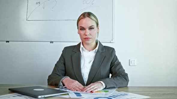 Young woman in a suit listening to a business project via video call