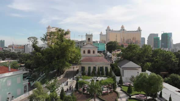 Flythrough / flyover of Carmel Park and Taipa Village in Macau with church in foreground and casino