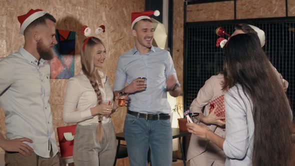 Girl Is Thanking and Hugging Her Colleagues for Christmas Gift on Party in Office