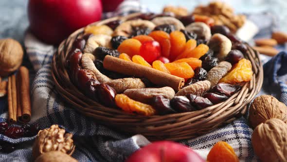 Composition of Dried Fruits and Nuts in Small Wicker Bowl Placed on Stone Table