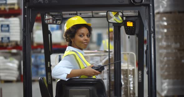 Female African Forklift Driver Working in Warehouse