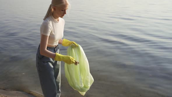 Woman with Garbage Bag on the Lake