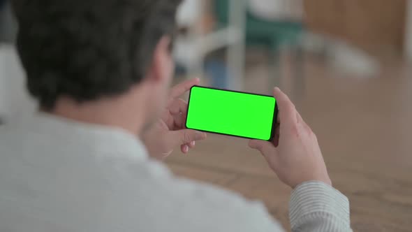 Young Man Looking at Smartphone with Chroma Screen