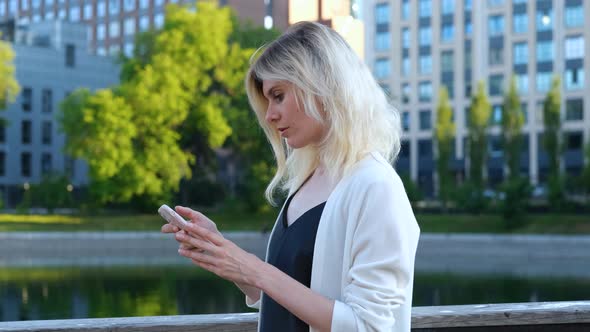 portrait of a woman using a smartphone on the background of the city