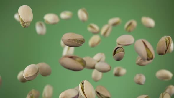 Close Up of Pistachios Bouncing on the Olive Green Background