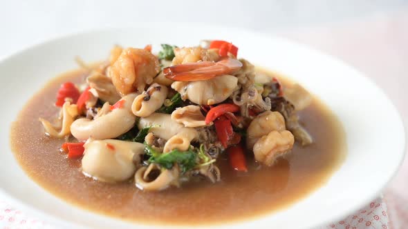 Squid and shrimp fried basil on a white plate