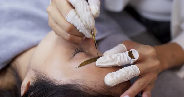 Young woman gets facial beauty procedure, microblading procedure