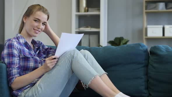 Casual Woman Reading Documents and Looking in Camera