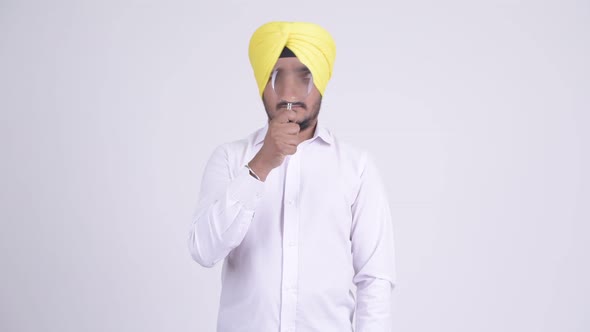 Bearded Indian Sikh Businessman Playing with Magnifying Glass
