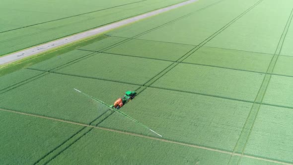 The Protection Of Plants.Tractor Spraying A Green Wheat Field