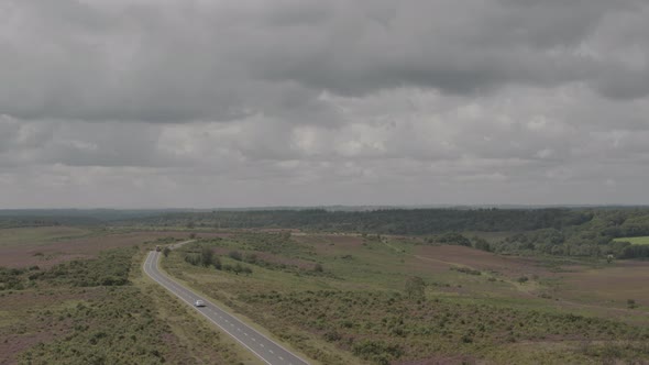 Aerial Drone Shot of English UK Countryside in The New Forest with Road and Cars in moody stormy wea