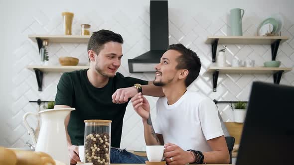 Young Male Couple are Sitting at the Kitchen Table Talking