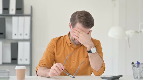 Young Man Having Headache in Office 