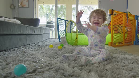 Happy Baby Girl Smiling and Playing with Bubbles at Home