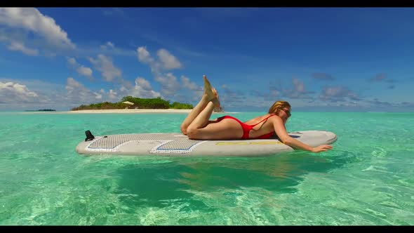 Teenage lovers tanning on beautiful tourist beach trip by blue sea and white sandy background of the