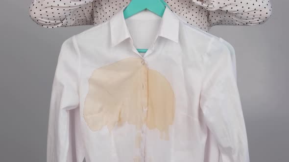 A Woman Compares Two White Shirts Before and After Washing