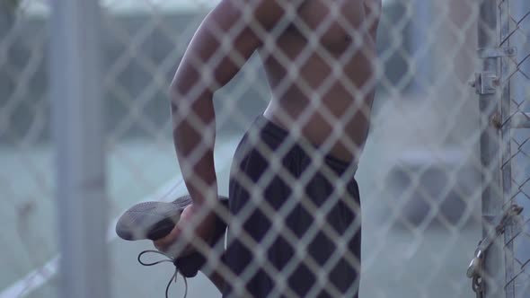 A young man playing basketball on a rainy day.