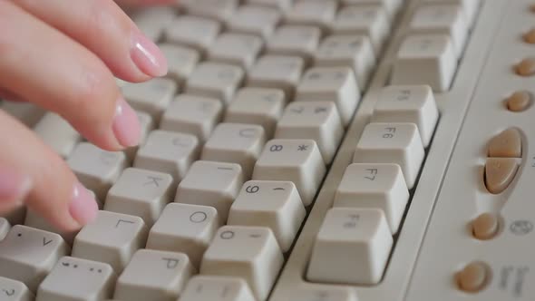 Female typing on aged white PC keyboard slow motion 4K 3840X2160 UHD video - Woman hands over beige 