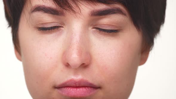 Extreme Close Up Portrait of Young Lady Opening Green Eyes Looking at Camera with Smile Isolated