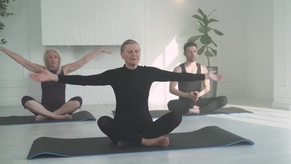 Wellness People of Different Ages Doing Yoga Group of People Relaxing in a White Room Filled with