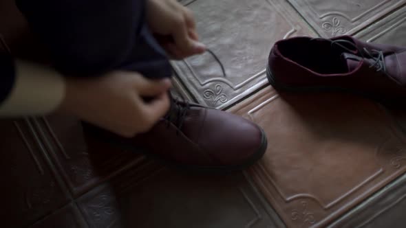 Man in tuxedo puts on shoes ties shoelaces, groom getting ready for wedding ceremony, accessories