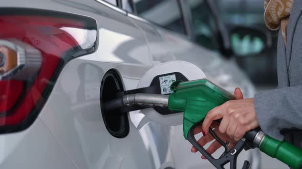 Woman Fills Petrol Into Her Car at a Gas Station Closeup