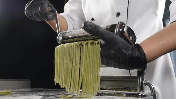 Traditional Italian Cuisine. Making Homemade Pasta, Close-up of Chef Makes Pasta Using Steel Machine