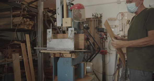 carpenter inspecting a wooden plank