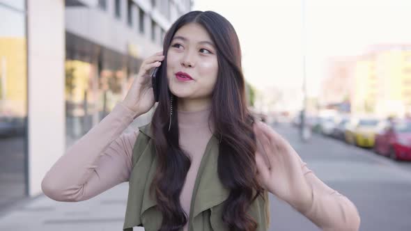 Young Asian Woman Talks Smartphone Smile Street Urban Area