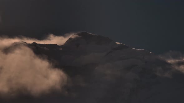 Beautiful scenery of snow caped mountain with cloudsing near by. Mountain peak with during sunset on