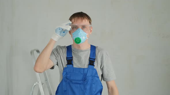 Handyman in Goggles and Hardhat Prepares for Work