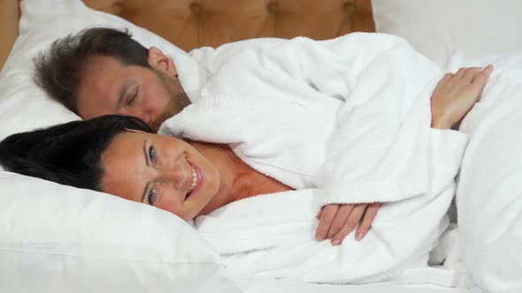 Cheerful Mature Woman Going To Sleep Lying in the Bed with Her Husband