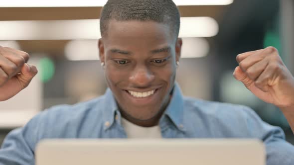 Successful Young African American Man Celebrating on Laptop