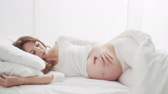 Pregnant woman touching her belly. Pregnancy, motherhood, and expectation concept.