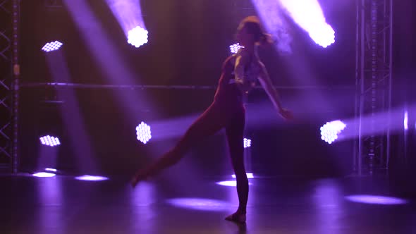 A Flexible Professional Female Athlete Performs Complex Acrobatic Elements of Rhythmic Gymnastics