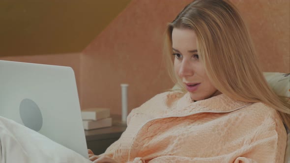 Full Length Side View of Female Patient Using Laptop on Bed in Hospital