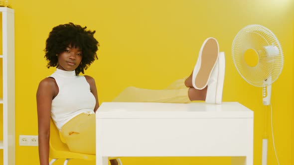 Portrait of African Woman Sitting In Yellow Interior