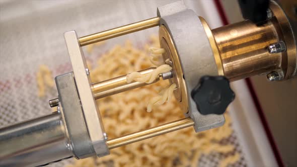 Tortiglioni Cazarece Spaghetti Pasta Falling From a Spout As They Travel Along the Production Line