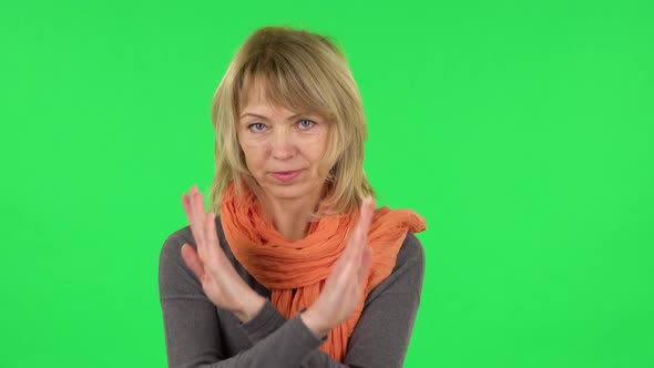 Portrait of Middle Aged Blonde Woman Strictly Gesturing with Hands Crossed Making X Shape Meaning