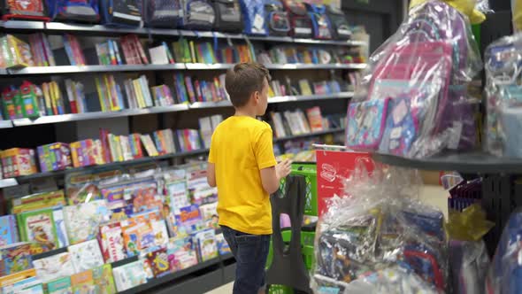 Boy choosing school supplies. Portrait of school boy shopping at supermarket
