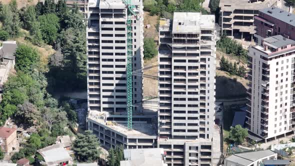 Big industrial tower crane work on high building construction site in Tbilisi city, Georgia