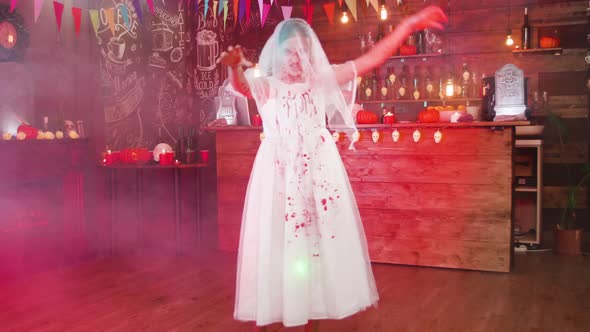 Young Girl Disguised As a Dead Bride with Her Dress Stained in Blood in a Halloween Decorated Pub