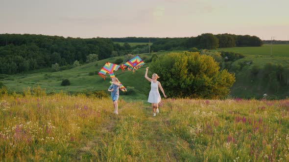 Happy Mom and Daughter Play Emotionally with an Air Kite, Run Through a Scenic Spot.