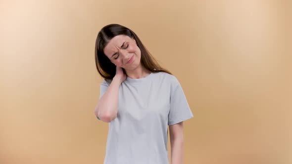 Woman with Muscle Injury Having Pain in Her Neck  Body Pain Portrait Shot on a Beige Background