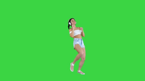 Caucasian Female Model in Headphones Jumping, Expressing Happy Emotions Listening To Music