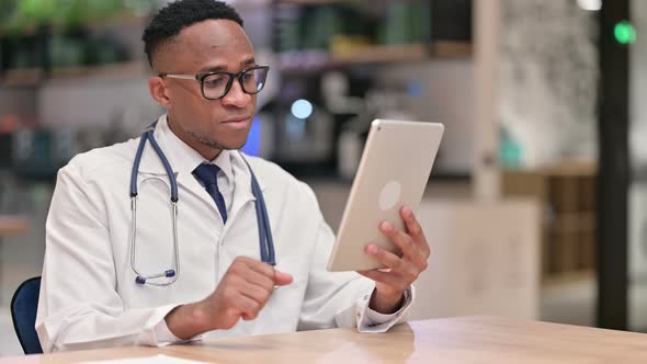 Serious Professional African Male Doctor Using Tablet in Office 